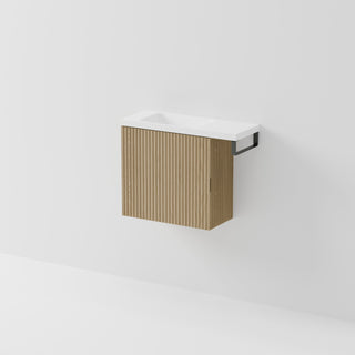 Aria 550 wall-hung WC vanity in Light Ash timber with an offset basin and integrated Gunmetal hand towel rail, shown against a white background.