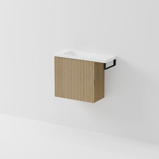 Aria 550 wall-hung WC vanity in Light Ash timber with an offset basin and integrated Matte Black hand towel rail, shown against a white background.