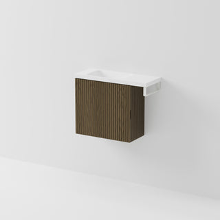 Aria 550 wall-hung WC vanity in Smoked Ash timber with an offset basin and integrated Matte White hand towel rail, shown against a white background.