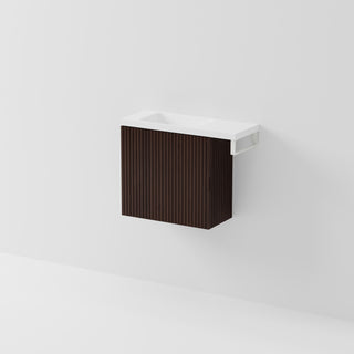 Aria 550 wall-hung WC vanity in Walnut Ash timber with an offset basin and integrated Matte White hand towel rail, shown against a white background.
