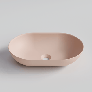 Pink solid surface sink on a light grey background