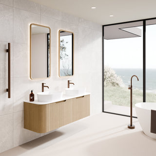 Modern bathroom interior with a floating double-sink vanity in light wood, two rectangular timber mirrors with wood-toned frames, a freestanding bathtub, and large windows overlooking the ocean.